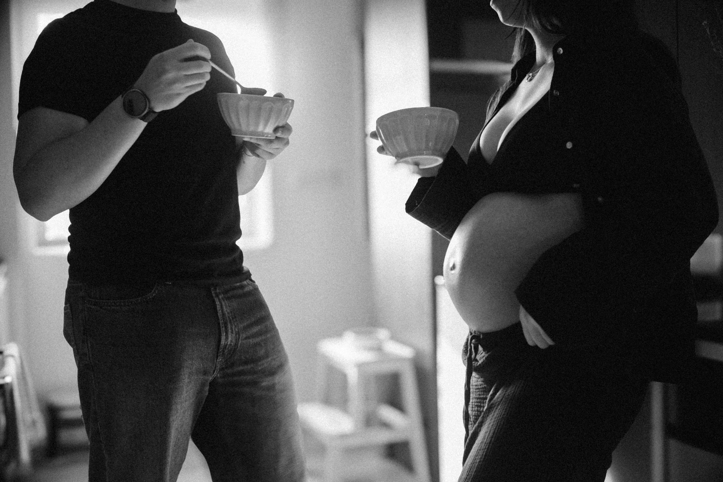 Fotografia a preto e branco de um casal com chávenas e pires na cozinha