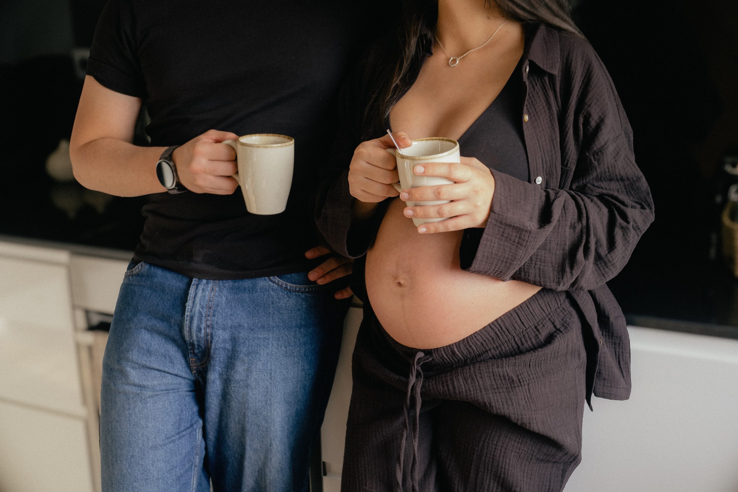 Casal à espera de um bebé na cozinha, num momento tranquilo com um café